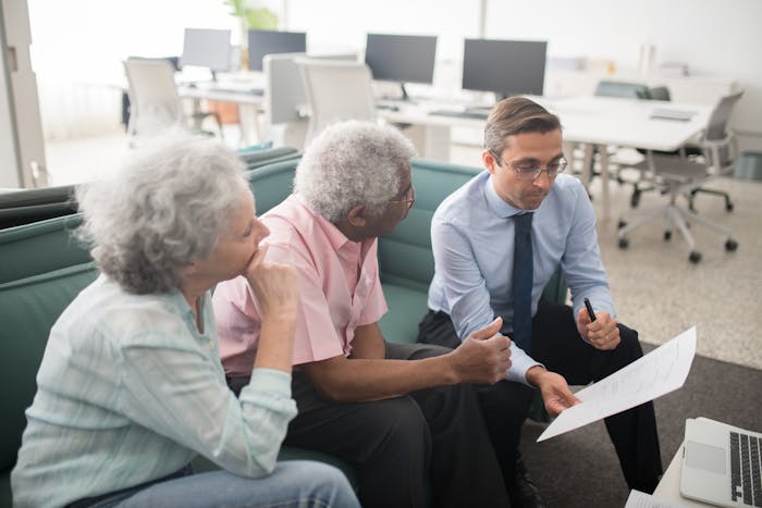 A financial advisor reviewing retirement planning documents with a senior couple