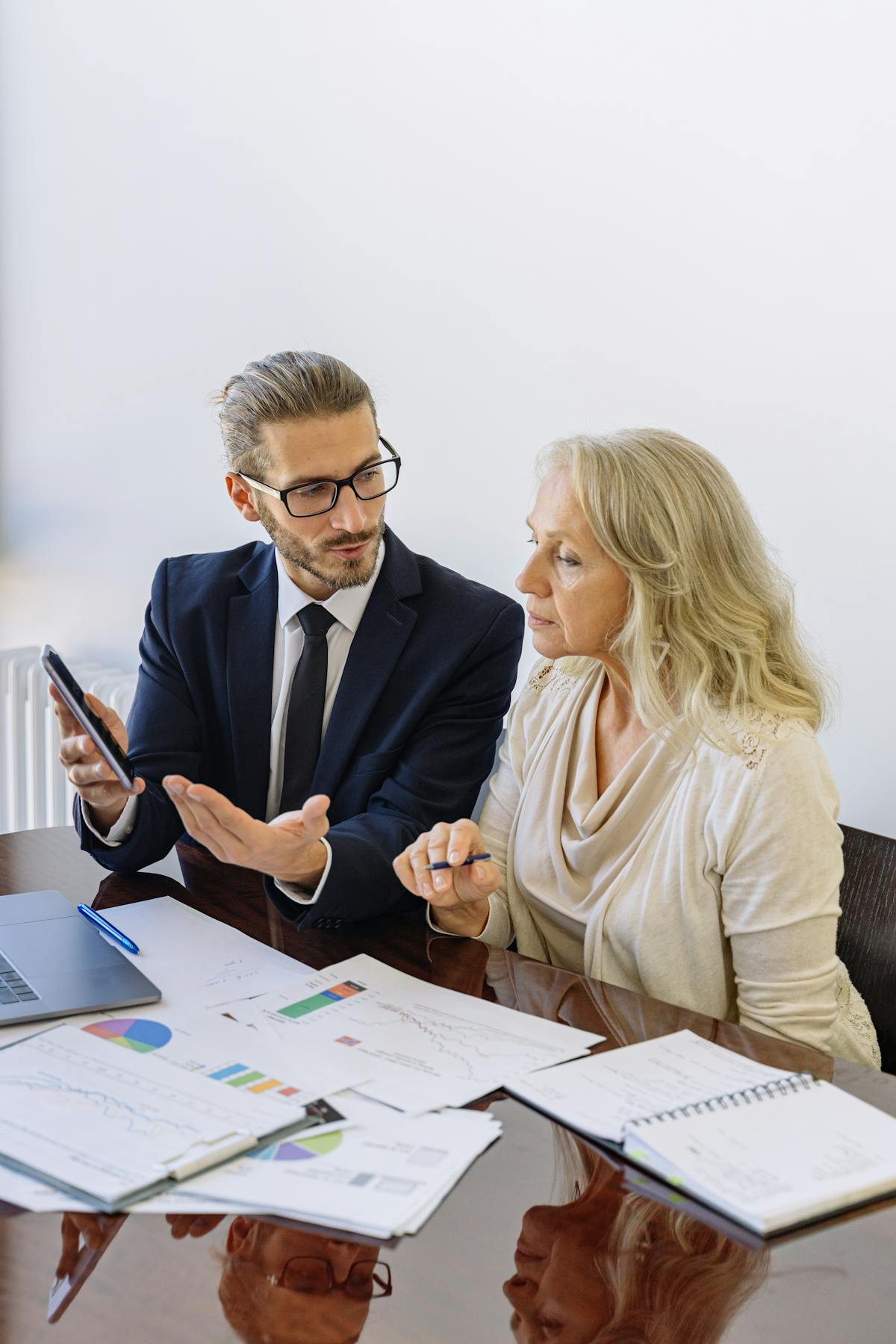 Licensed financial advisor explaining rollover options to a client with charts